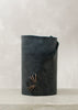 Image of navy leather wrapped vase stitched with charcoal leather cord on a stone table.
